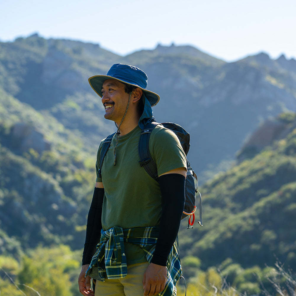 a man in the mountains in a hat 