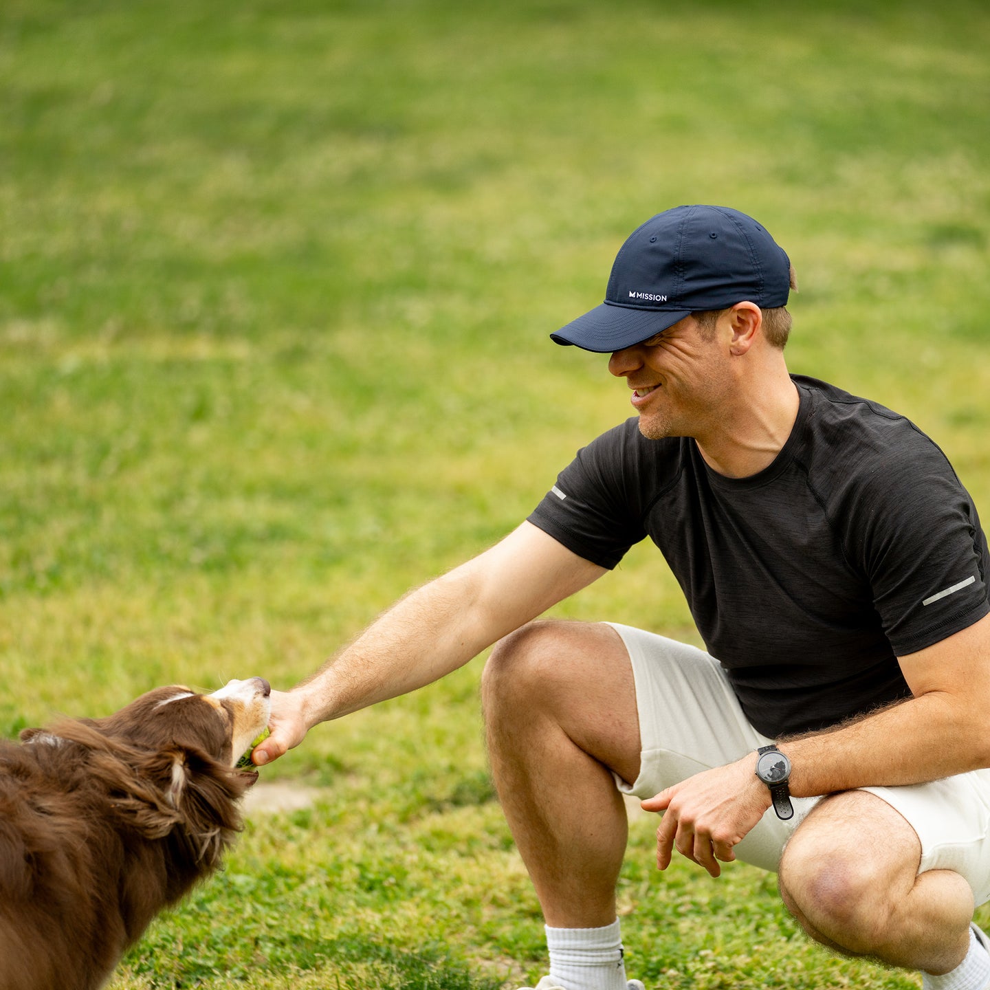 A man in sportswear plays with a dog 